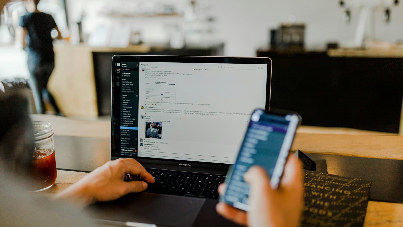 Personne échangeant des messages sur téléphone et ordinateur