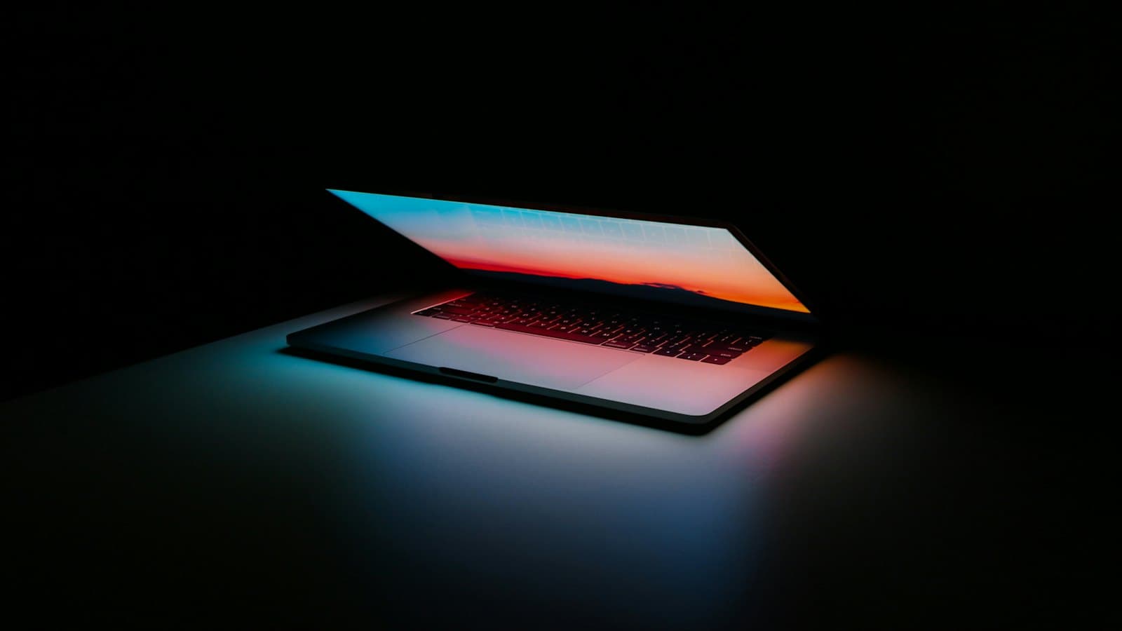 Ordinateur portable entrouvert éclairé dans l'obscurité